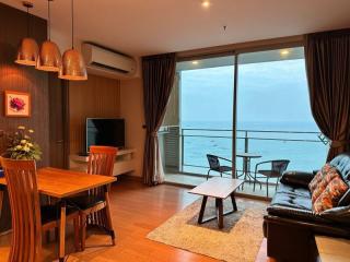 Cozy living room with ocean view, modern furniture, and balcony access