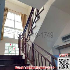 Elegant staircase with wooden banister in a well-lit interior space