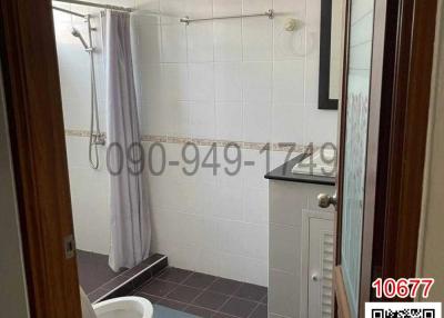 Spacious bathroom with white fixtures and shower curtain