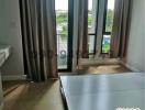 Bright bedroom with large windows and balcony access