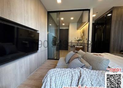 Modern bedroom with large bed, mounted TV, and balcony access