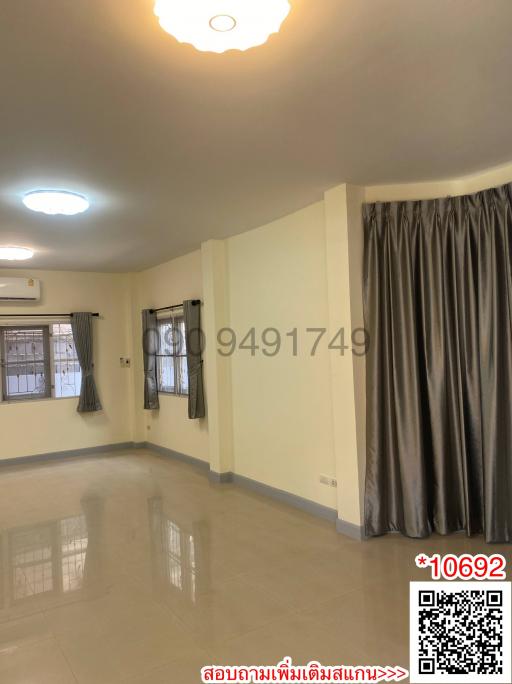 Spacious and well-lit empty room with glossy floor, large windows with curtains, and a central decorative light fixture