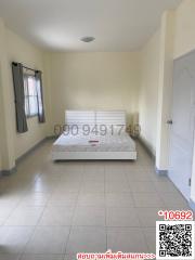 Spacious and well-lit bedroom with a large bed and tiled flooring