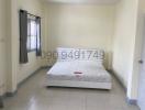 Spacious bedroom with large window and tiled flooring