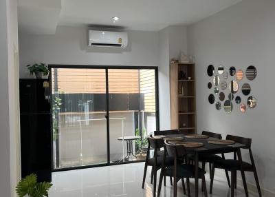 Modern dining area with natural light, adjacent to the balcony