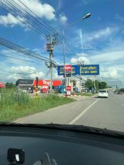 View of a street from the car showing other vehicles, commercial signs, and clear blue sky