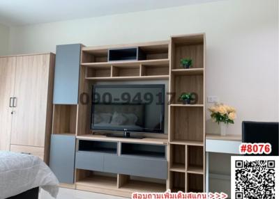 Cozy bedroom with contemporary wooden entertainment unit and large bed