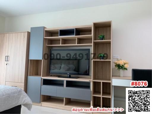 Cozy bedroom with contemporary wooden entertainment unit and large bed