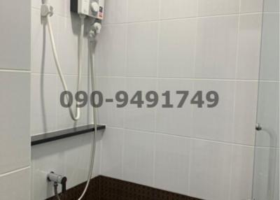 Modern bathroom with wall-mounted electric heater and handheld shower