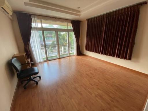 Spacious and empty living room with large windows and wooden flooring
