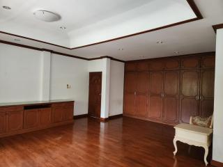 Spacious living room with hardwood flooring and elegant wood paneling