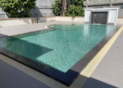Modern outdoor swimming pool with clean water and surrounding patio area