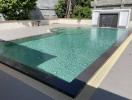 Modern outdoor swimming pool with clean water and surrounding patio area