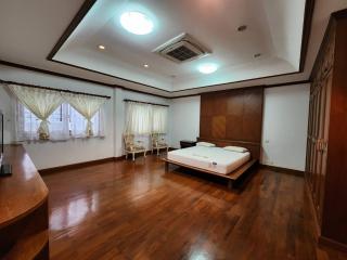 Spacious bedroom with hardwood flooring and ample natural light