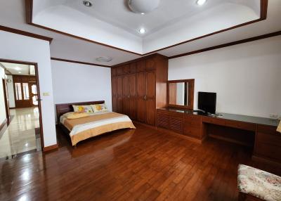 Spacious bedroom with wooden flooring and built-in wardrobes