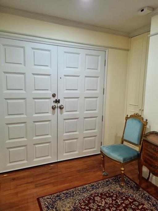 Elegant entryway with wooden doors and vintage chair