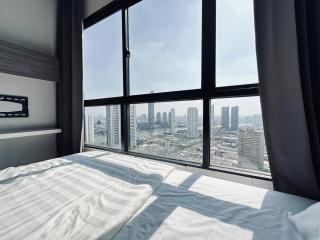 Modern bedroom with large windows offering city views