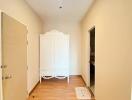 Spacious hallway with wooden flooring and a white wardrobe