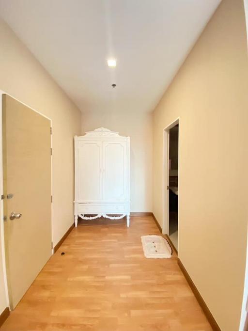 Spacious hallway with wooden flooring and a white wardrobe