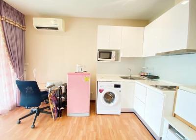 Studio apartment with kitchenette, compact living area with office chair