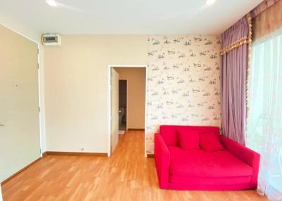 Bright living room with red sofa and wooden floors