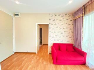 Bright living room with red sofa and wooden floors