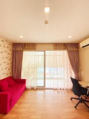 Bright and cozy living room with red sofa and office chair