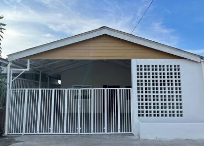 Front view of a modern single-story house with a white gate