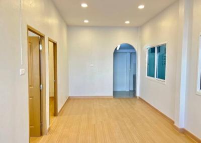 Spacious unfurnished bedroom with wooden flooring and ample natural light
