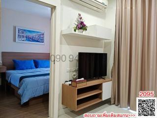 Cozy bedroom with queen-size bed, modern TV, and air conditioning unit