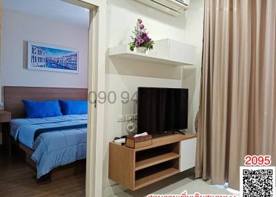 Cozy bedroom with queen-size bed, modern TV, and air conditioning unit