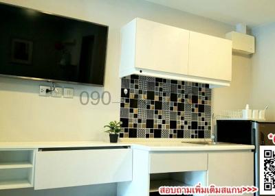 Modern kitchen with white cabinetry and black and white backsplash