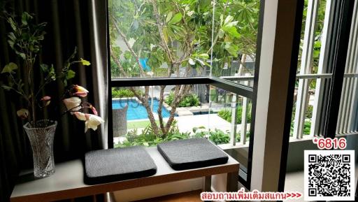 Cozy seating nook with pool view through window