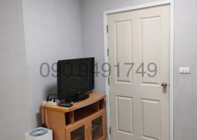 Compact living room with television and white door