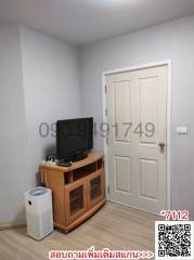 Compact living room with television and white door