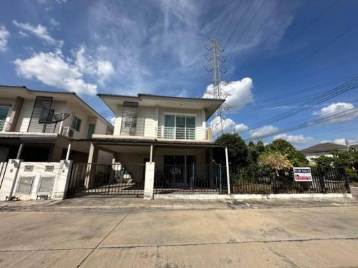 Modern two-story house with a clear blue sky and a for sale sign