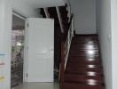 Bright entryway with wooden staircase and tiled floor