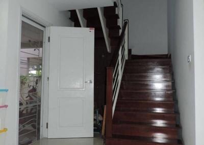 Bright entryway with wooden staircase and tiled floor