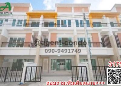 Front view of a modern multi-story residential townhouse with balconies and gated entrance