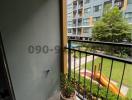 Compact balcony with a view of apartment building and greenery