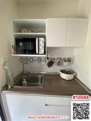 Compact kitchen with modern appliances and white cabinetry