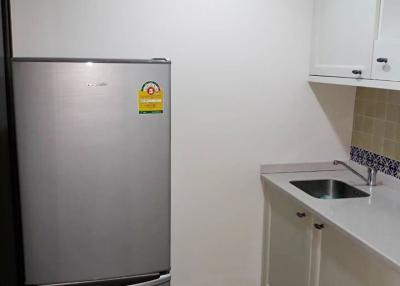 Modern kitchen with stainless steel refrigerator and small sink