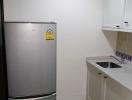 Modern kitchen with stainless steel refrigerator and small sink