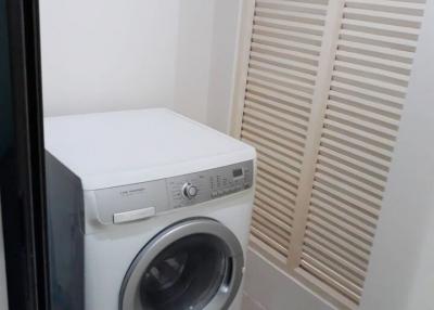 Compact laundry room with a modern washing machine