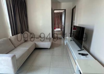 Spacious living room with sofa, air conditioning, and adjacent bedroom view