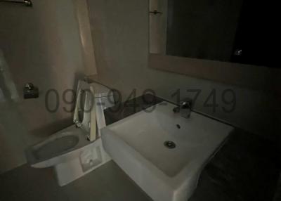 Dimly lit bathroom with sink and toilet