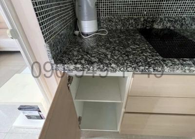 Modern kitchen countertop with mosaic tile backsplash and under-cabinet storage