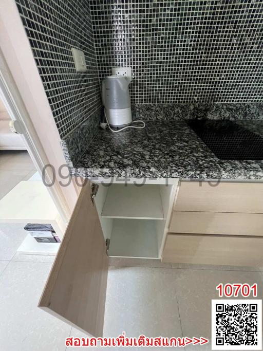 Modern kitchen countertop with mosaic tile backsplash and under-cabinet storage