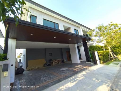 Wide-angle view of a two-story residential building with covered parking area