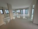 Spacious and bright empty room with large windows and glossy tiled floor